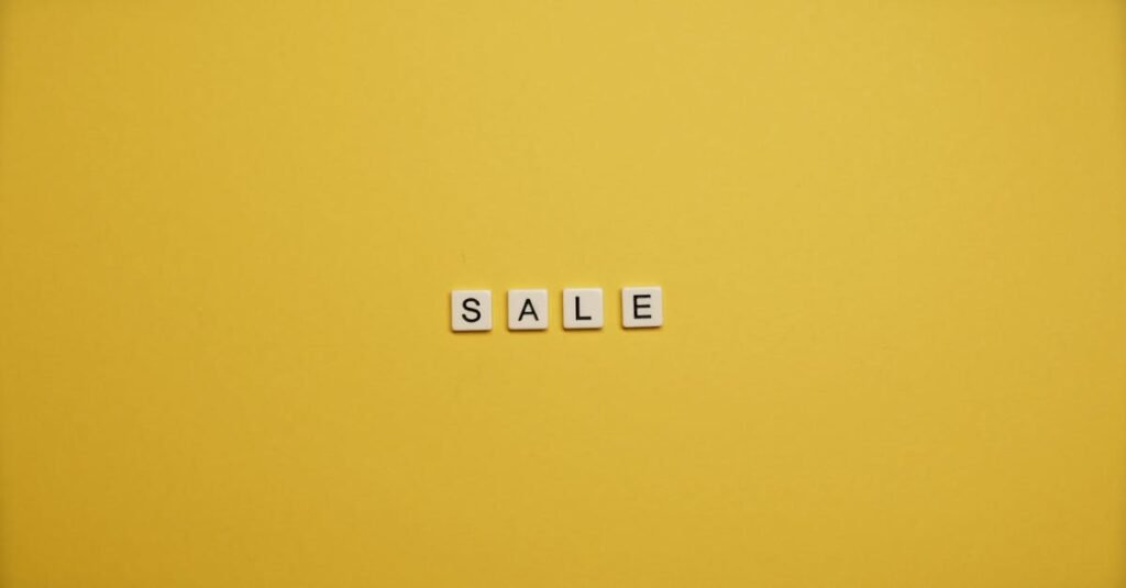 Single word 'SALE' spelled with tiles on a bright yellow background, ideal for advertising.
